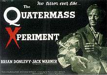 A black and white photograph, tinted green, of a man, standing to the right, against a black background. His eyes are sunken into a gaunt face and he is holding out his right arm, which is horribly deformed. Left and centre is the film's tagline and title: "No terror ever like…" and "The Quatermass Xperiment" in white lettering, except for the 'X' in 'Xperiment', which is in red. Below, in white lettering, are the names of Brian Donlevy and Jack Warner, the film's top-billed stars.