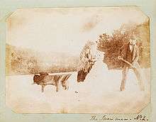 Salt print photograph of a man and woman building a snow man, circa 1853