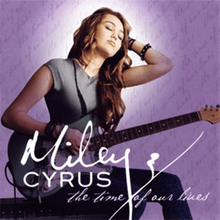 The right profile of a long-haired brunette teenager holding a green and white colored, electric guitar with her face tilting up. She is wearing a gray tee-shirt and blue zebra-patterned pants. Beneath her are letter stating in cursive "Miley Cyrus" and "The Time of Our Lives". The background is purple and has cursive writing on it.