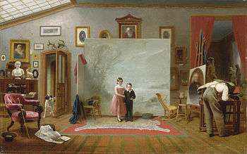 Two children pose for a photograph in an artist's studio.