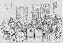 men at table in military uniforms, others standing