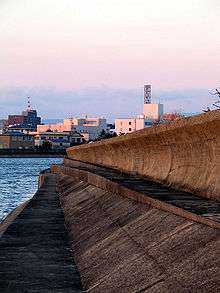 Photo of seawall with building in background