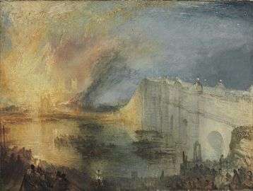 On the right, a white stone bridge arches over a wide river. On the far side and to the left, a gabled building is outlined in front of huge flames rising up to the night sky; they are reflected in the water and illuminate part of the bridge and a building with two towers in the background. There are several boats full of people in the river, and large crowds are assembled on the near bank and on the bridge.