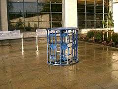 A defunct turnstile on paving outside a supermarket