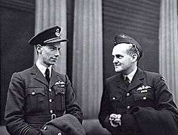 Informal half portrait of two men in dark military uniforms with pilot's wings on the left pockets