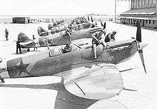 a black and white photograph of a row of single-engined aircraft with stars on their sides