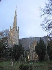 A Gothic style church seen from the south; to the left is a tower with a spire and pinnacles; to the right is a two-storey, gabled transept.