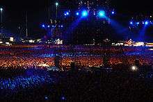 Darkened stadium concert, with blue lights