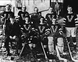 group of men posed in hockey uniforms outside