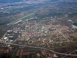 An aerial view of motorway cloverleaf interchange and airport runway