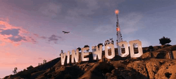 The summit of an in-game mountain with eight billboards displaying letters spelling out the word "Vinewood"