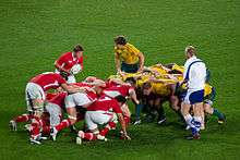 Two packs of players crouched before commencing a scrum
