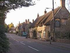 Street scene with buildings on the right including a pub with sign The Castle.