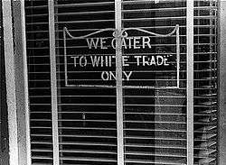 A sign reading "We Cater to White Trade Only"