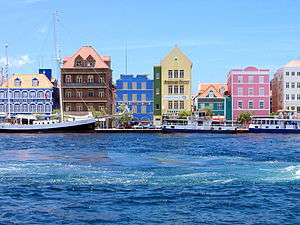 Port with colorful houses in blue, brown, green, yellow, pink.