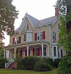 Front view of house from slightly off-center, showing decoration on roofline