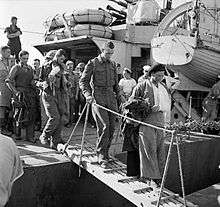 A black and white photograph showing wounded British soldiers disembarking from a warship