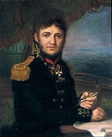 Half-length portrait of a man looking over his shoulder. His hair is thick and curly, and he wears a dark blue jacket with epaulettes and gold buttons, with a medals around his neck. In his hand he holds a compass, and in front of him is a chart.