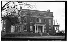 A picture of the house in black and white, with an older automobile parked to its left