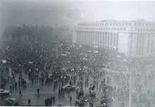 Demonstration in front of large, square building