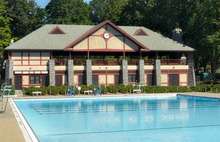 An outdoor pool and two-story building with a large pediment